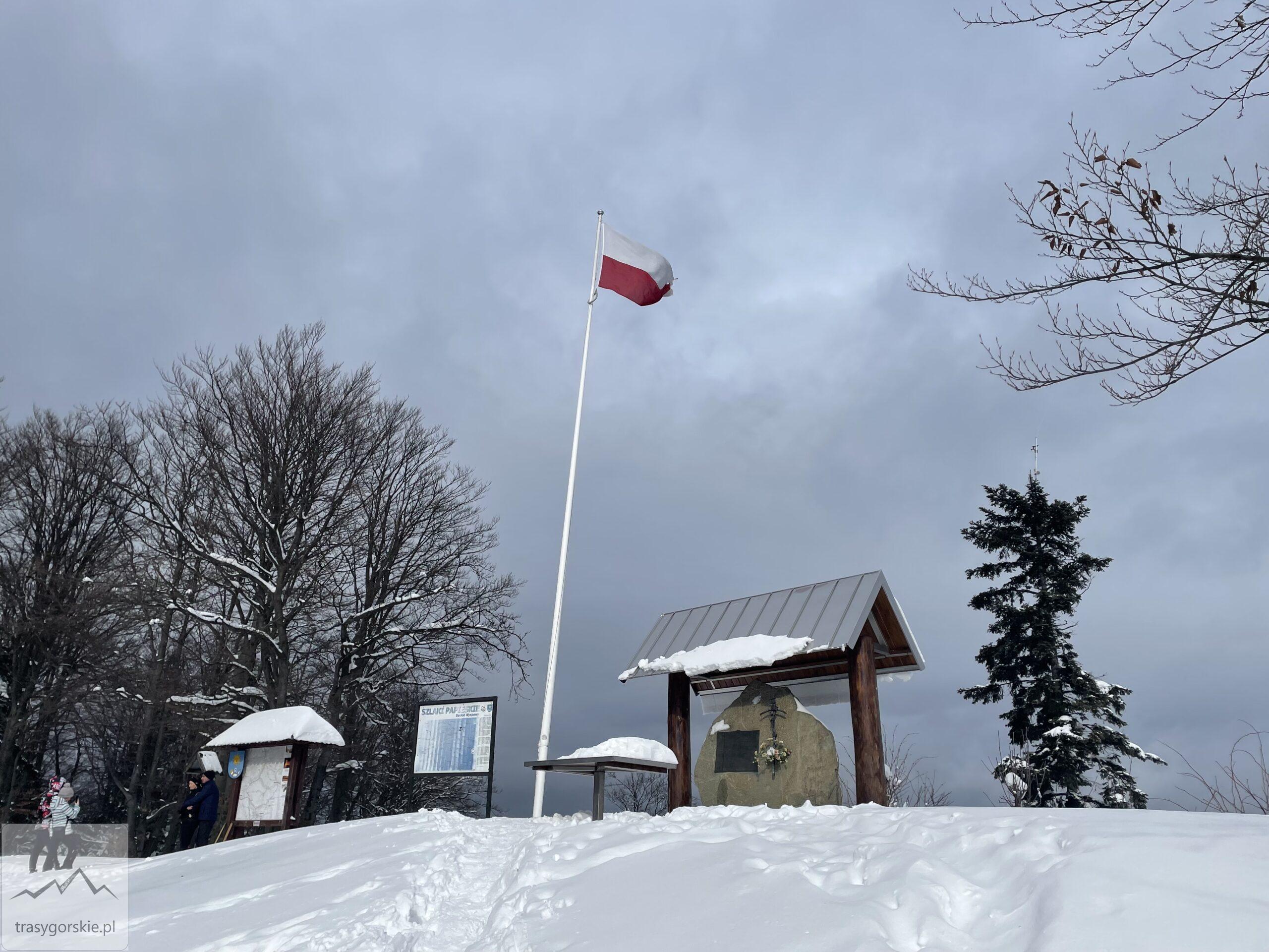 Tablica upamiętniająca Jana Pawła II oraz flaga Polski na Szczeblu